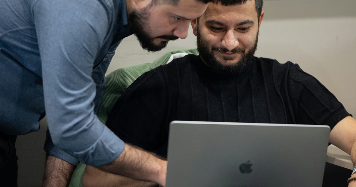 Developers reviewing code together on a laptop