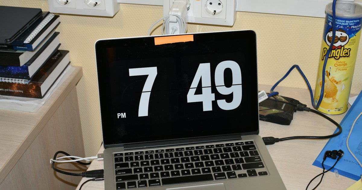 Digital clock displayed on a laptop at a desk