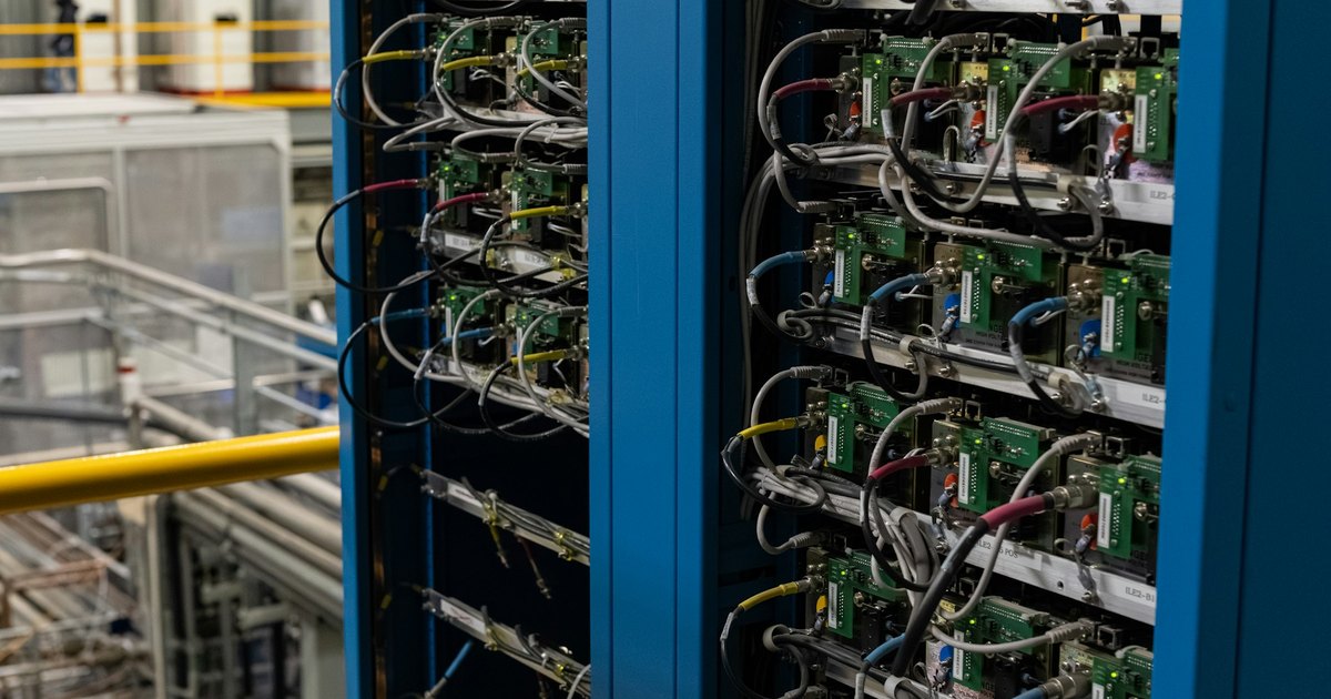 Blue server racks filled with cables and electronic components